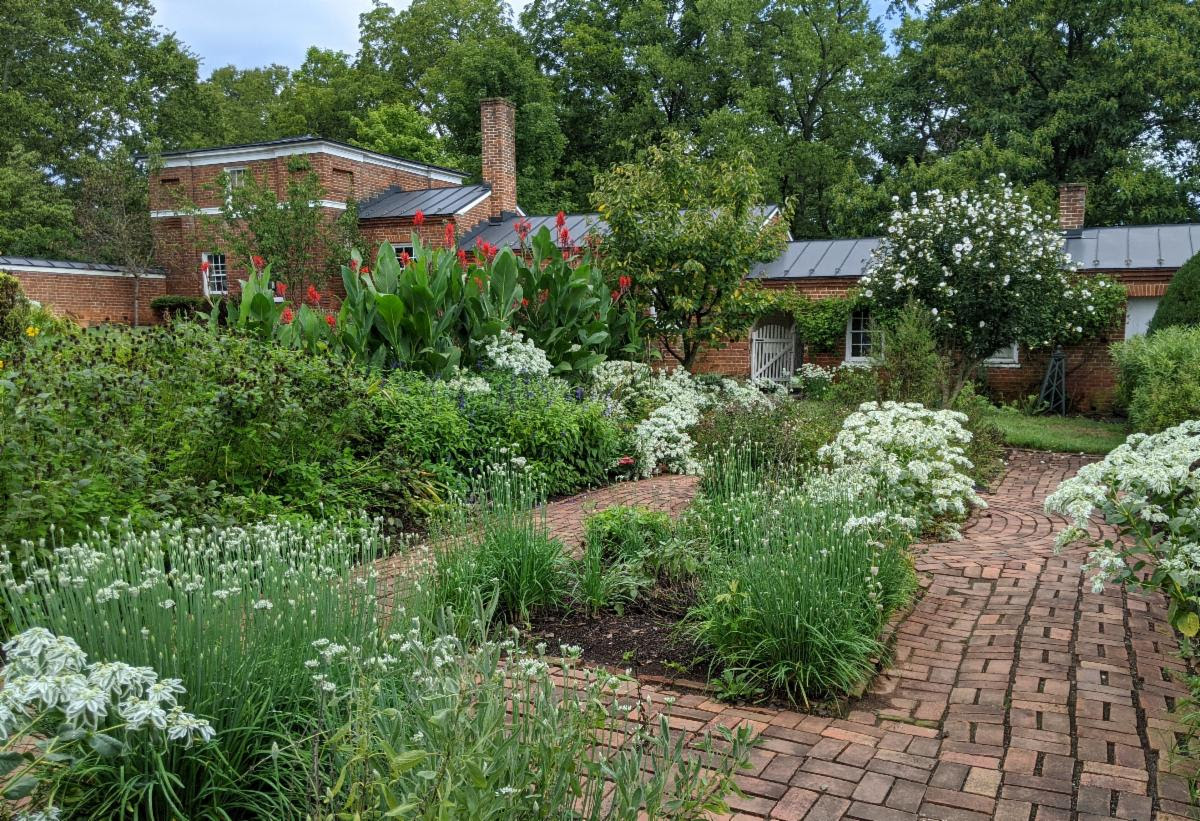 Photo of the herb garden in front of the historic brick dependency buildings at Oatlands.